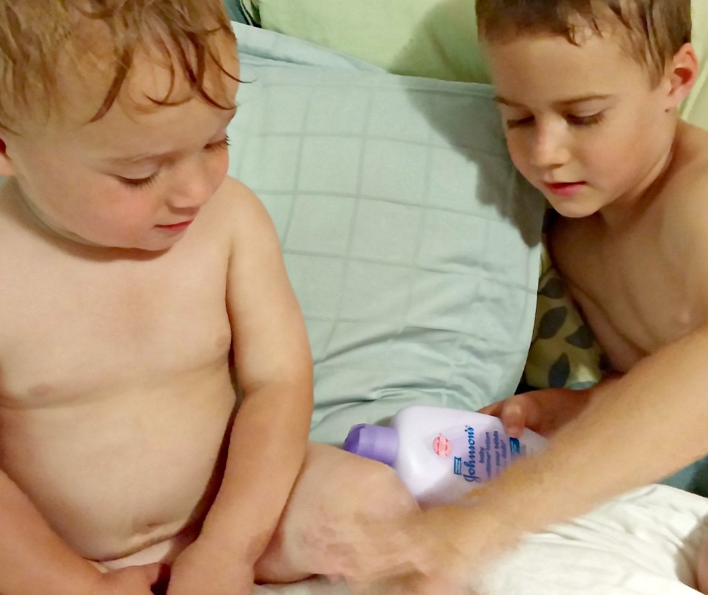 Kyle helping lotion his brother